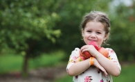 A child holds apples at Apple Jack Orchards in Delano