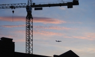 A plane flies past the Nolan Mains construction site in Edina.