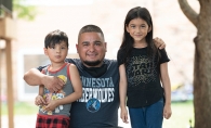 Man posing with two children.