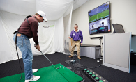 A golfer practices his swing at Golftec.