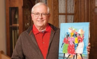 Dr. Jim Rohde, volunteer and board member with Healing Hands for Haiti, in his home with a piece of Haitian art. 