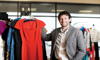 Clothes Mentor owner Dan Canfield holds a red dress.
