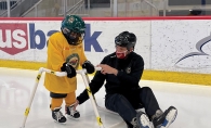 Coach teaches young hockey player to stake