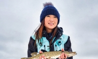 Woman holding fish caught while ice fishing