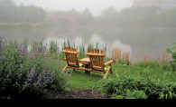 Two wooden chairs sit near the water in Centennial Lakes Park.