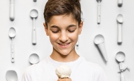 Boy holding double scoop of ice cream in a cone.