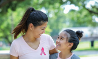 A mother and daughter wear pink breast cancer awareness shirts.