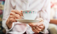 A woman drinks tea at a Memory Cafe event