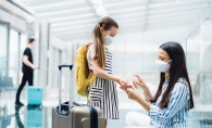 Woman spraying hand sanitizer on child's hands