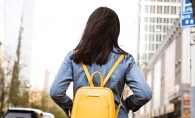 A woman wears a yellow backpack. Backpacks are a hot fall fashion trend, according to Wendy Witherspoon of Prink Style.