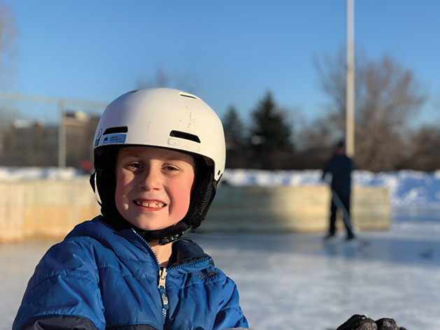 A young hockey player smiles for the camera.