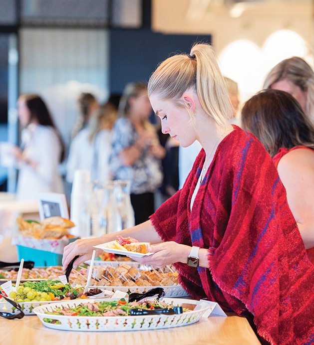 A guest puts food on her plate at the Evereve Minneapolis Influencer Social