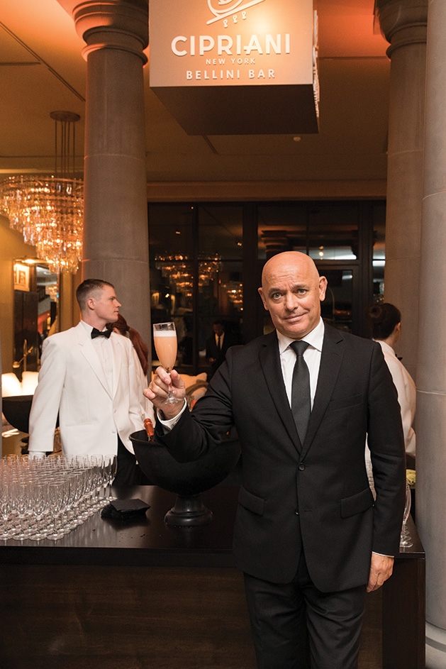 A man holds a glass of champagne at the Restoration Hardware Edina grand opening.