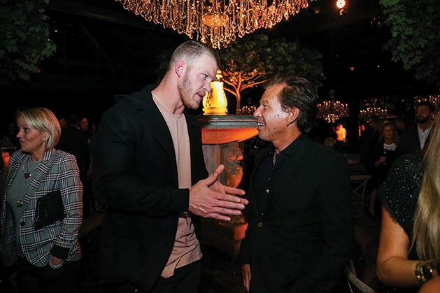Kyle Rudolph speaks to another man at the Restoration Hardware Edina grand opening.