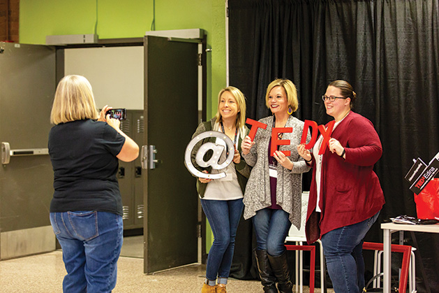 TEDx attendees make the most of their break time with some photo prop fun. 