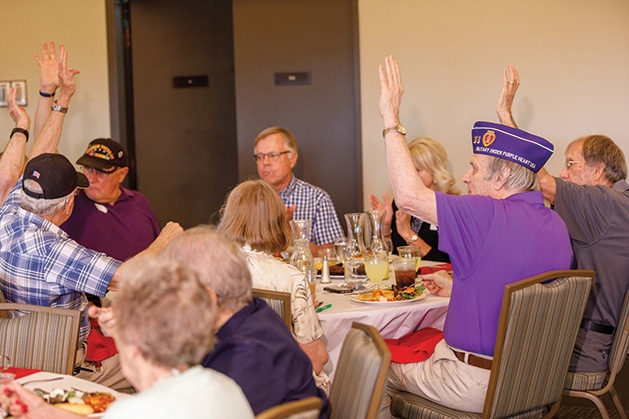 A veteran raises his arms at the Edina Veterans Dinner