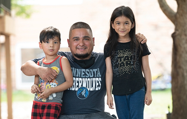 Man posing with two children.