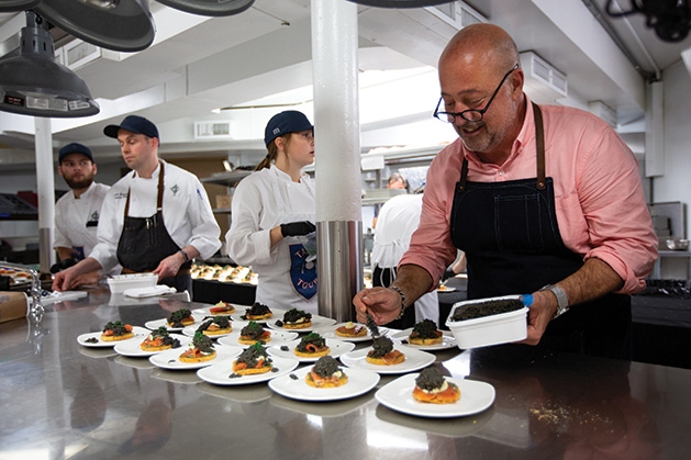 Andrew Zimmern prepares food for Taste Fore the Tour