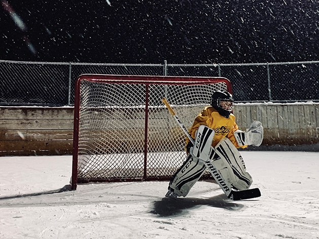 Child goalie in front of hockey net