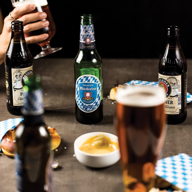 Oktoberfest table filled with beer bottles and pretzels.