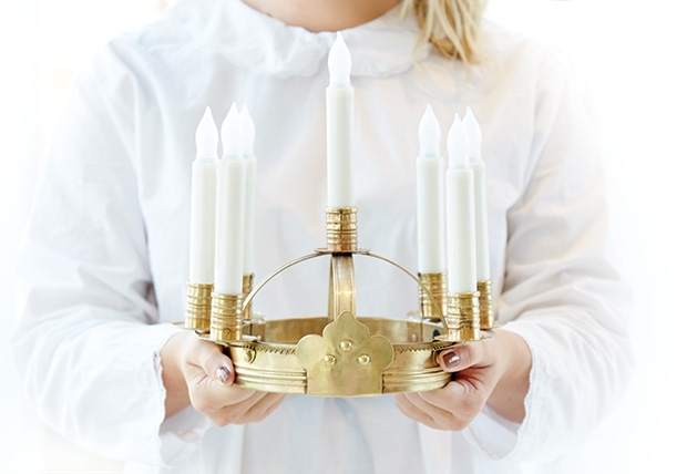 A woman holds a crown of candles for the St. Lucia concert at the American Swedish Institute