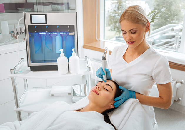 A woman receives a hydrafacial to combat sun damage.