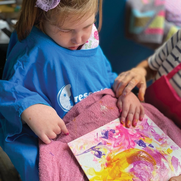 Little girl painting on Ziggy's Art Bus.