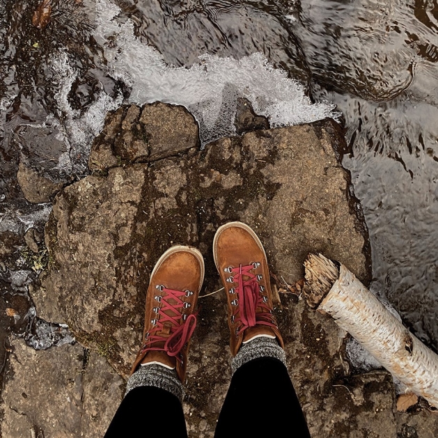 Travel blogger Lizanne Lately standing on a rock overlooking Lake Superior.