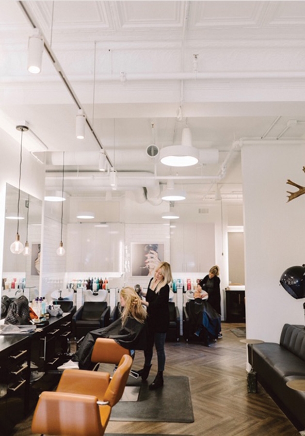 A hairstylist works on a customer's hair at Sloane's Beauty Bar.