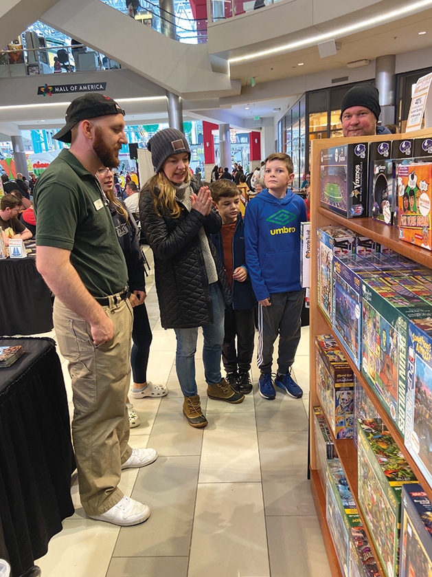 Shoppers explore products for family game night at Games by James' 40th anniversary celebration