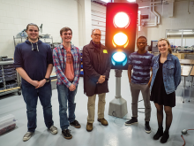 Students gather around a traffic light in an engineering class.
