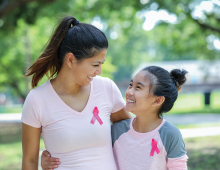 A mother and daughter wear pink breast cancer awareness shirts.
