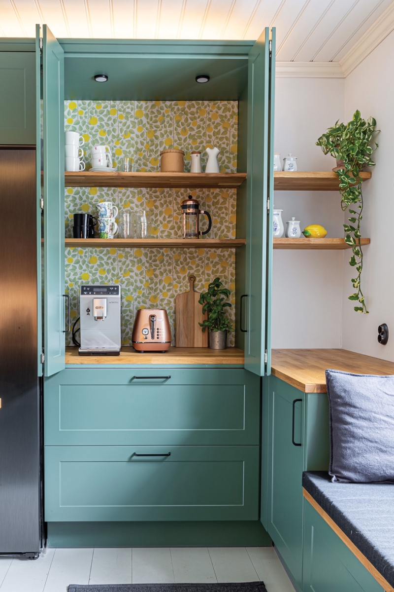 Breakfast pantry in light green with a patterned wallpaper.