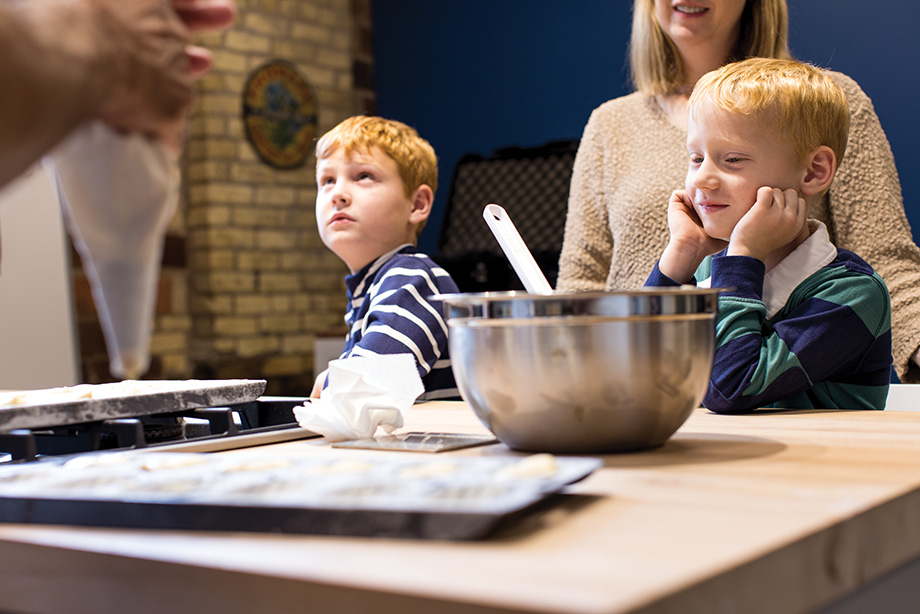 Brothers Julian and Sebastian Vessey observing the process of baking Madeleine cookies.