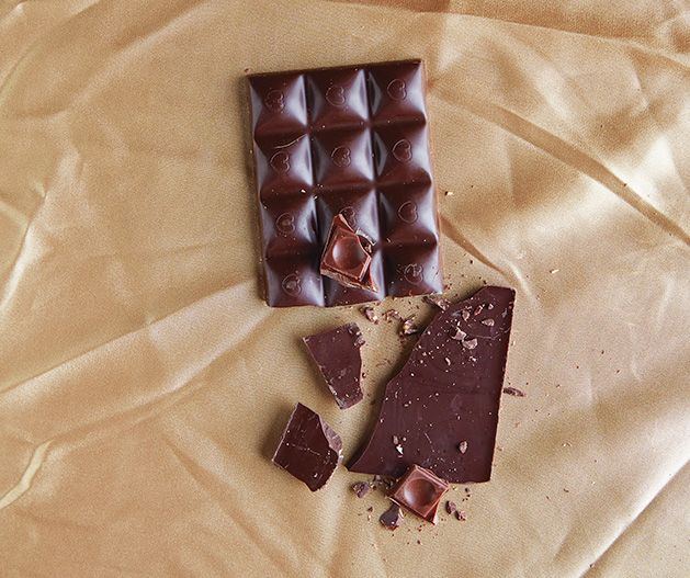 A bar of chocolate on a gold satin sheet