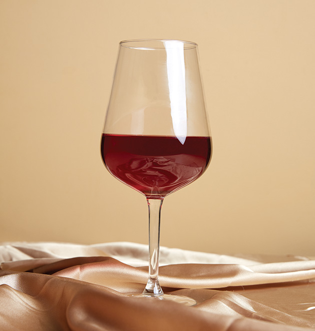A glass of wine on a gold satin sheet