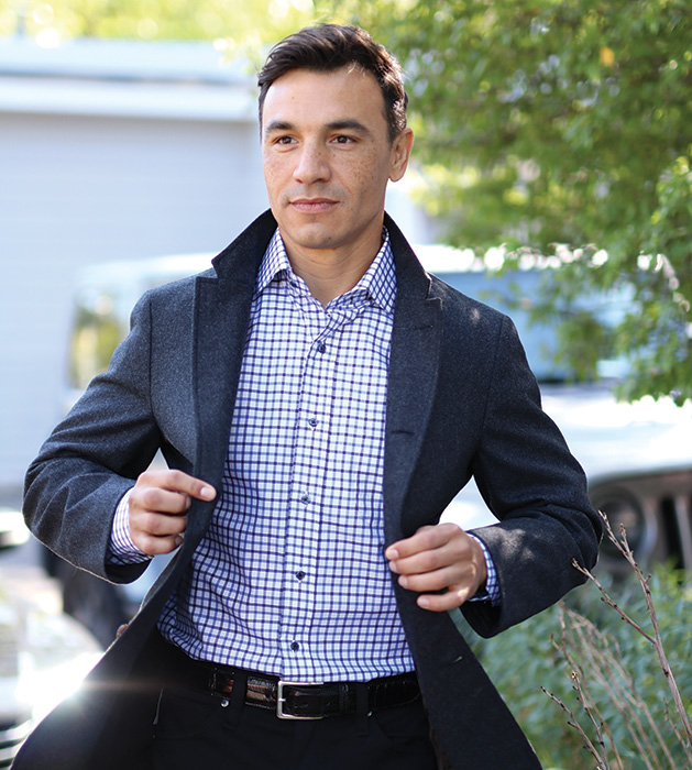 A man models a charcoal sport blazer, brown and navy dress shirt and black wool pants from CircleRock