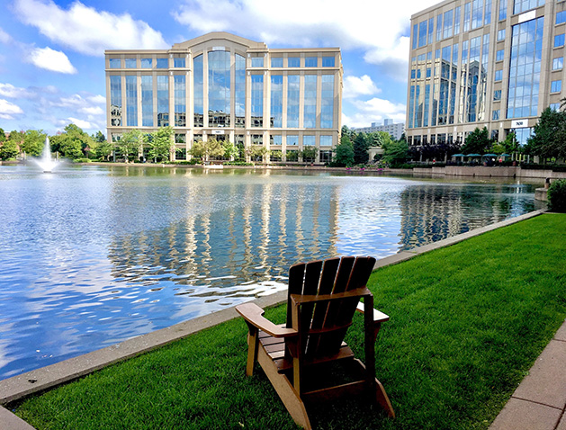 Office buildings are reflected in the water at Centennial Lakes Park.